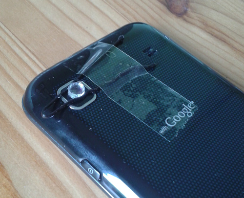 Laser pointer lens held over the phone's camera with a hair-clip and tape.